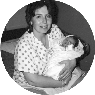Mother holding newborn baby in hospital bed, black and white
