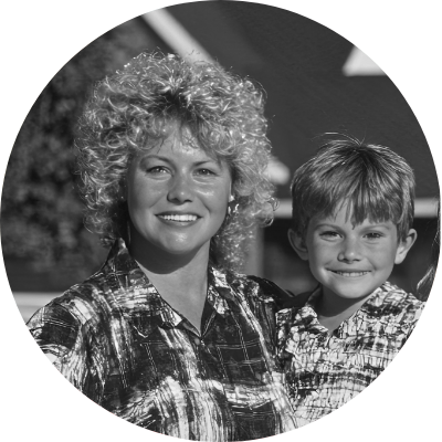 Black-and-white photo of mother standing with young child